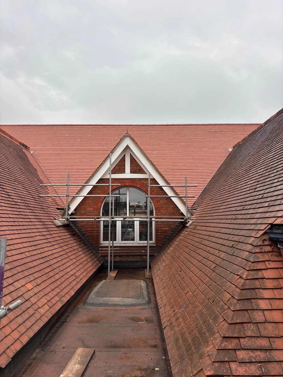Red clay tiled roof gable with attic window