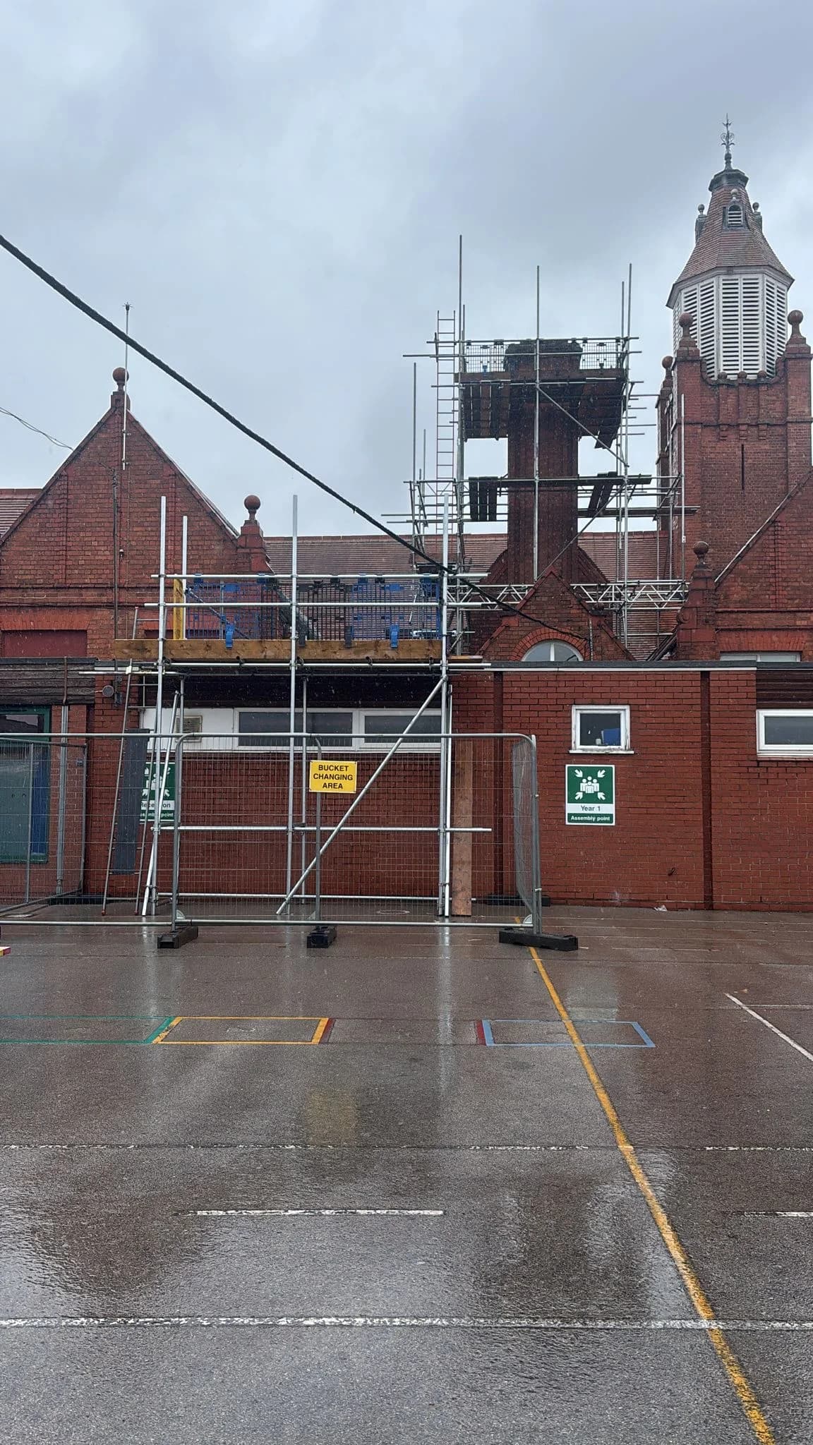 Building with tower and scaffolding on a rainy work day