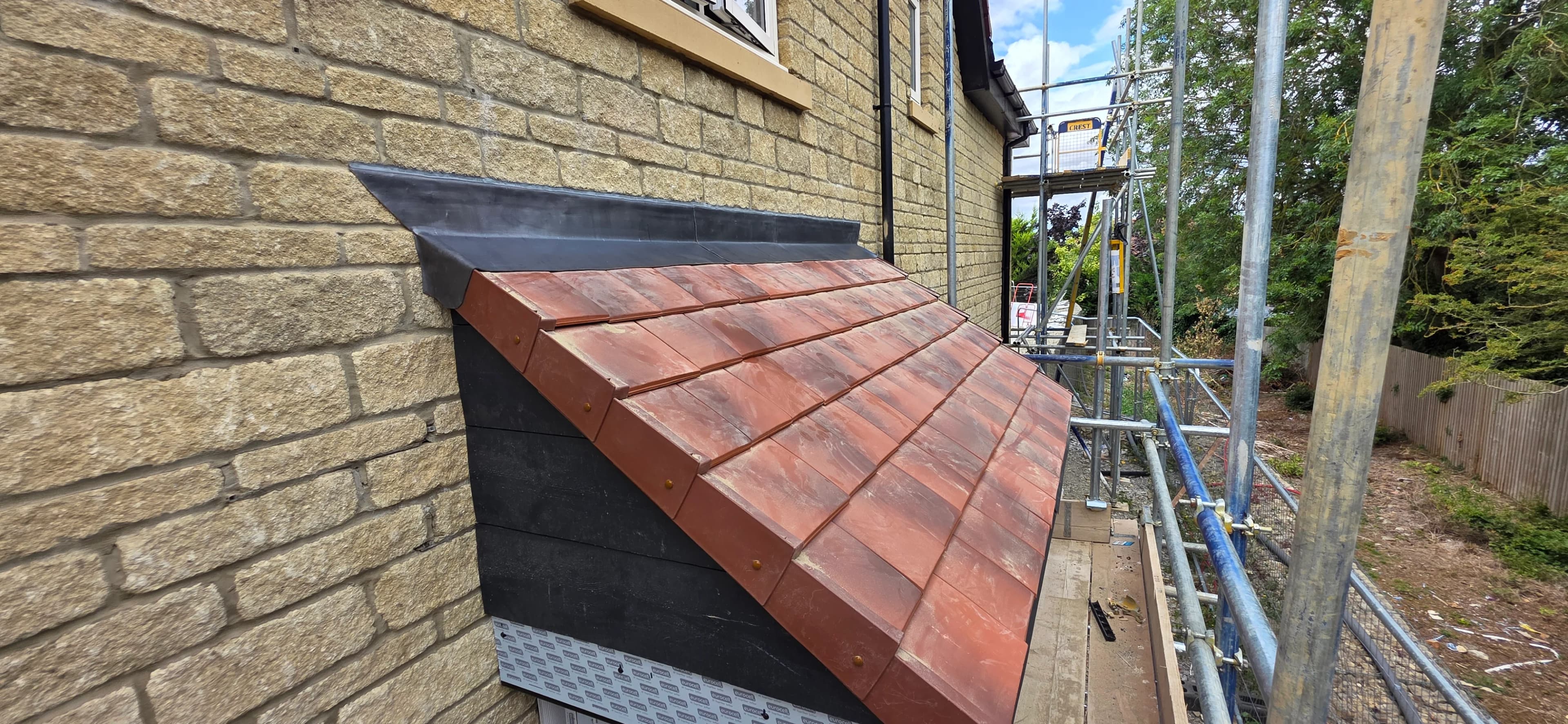 New clay tiled roof section on a house corner